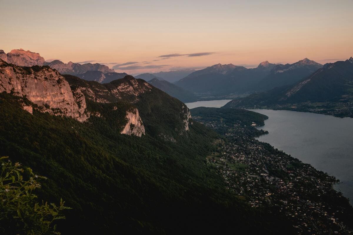 Vue panoramique sur le lac d’Annecy et les montagnes environnantes au coucher du soleil